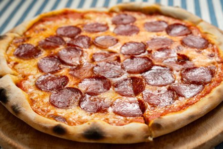 Traditionelle italienische Pfefferoni-Pizza in Scheiben geschnitten, aus nächster Nähe. Italienisches Pizzeria-Konzept