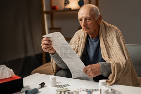 Ein älterer Mann liest eine Anleitung, wie man Tabletten einnimmt. Kopierraum