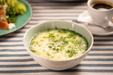 Italian stracciatella egg drop soup with parmesan cheese in white bowl on table. copy space