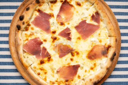 Pizza italienne au fromage et tranches de jambon dans une pizzeria en Italie. Vue du dessus