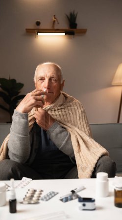 Téléchargez les photos : Malade homme âgé utilisant goutte nasale pour le nez bouché. Homme retraité avec grippe et nez qui coule. Maladie, concept de maladie - en image libre de droit