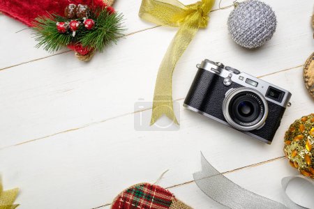 Téléchargez les photos : Composition festive avec appareil photo et décorations de Noël colorées sur fond blanc en bois avec espace pour le texte - en image libre de droit