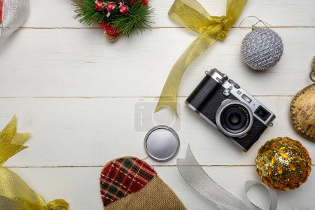 Téléchargez les photos : Composition festive avec appareil photo et décorations de Noël colorées sur fond blanc en bois avec espace pour le texte - en image libre de droit