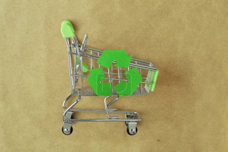 Foto de Cesta verde con símbolo de reciclaje sobre papel reciclado - Concepto de ecología y compras responsables - Imagen libre de derechos