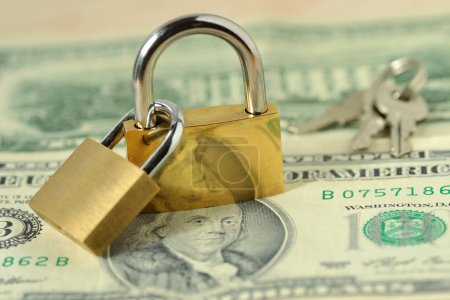 Two locked padlocks on dollar banknotes - Concept of financial security