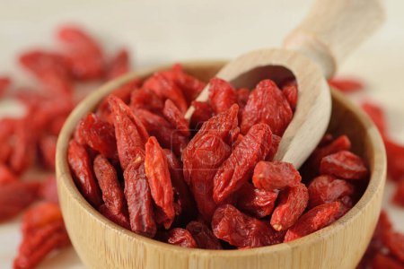 Close-up of dried goji berries with spoon in wooden bowl