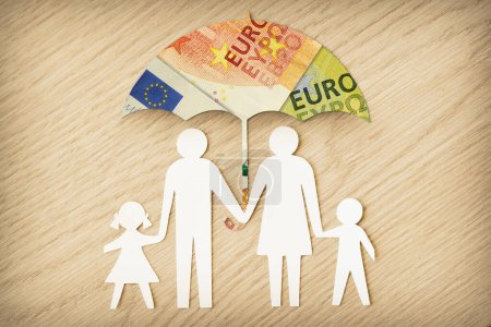 Téléchargez les photos : Silhouette de famille de papier avec parapluie en billets en euros sur fond bois - Concept de protection financière familiale - en image libre de droit