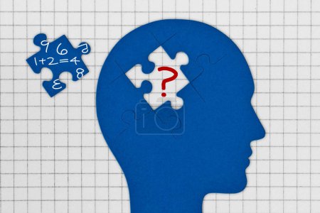 Kopfprofil mit Gehirn aus Puzzleteilen auf quadratischem Papier - Konzept der Dyskalkulie und Probleme mit Zahlen