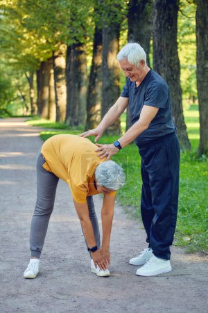Photo for Elderly married couple working out, doing exercises outdoors. Healthy sportive lifestyle or retirees concept - Royalty Free Image