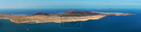 Téléchargez les photos : Wide angle view from above, aerial shot of La Graciosa, volcanic island surrounded by the Atlantic Ocean, photo taken from Lanzarote Island, Canary Islands of Spain. Travel destinations and tourism - en image libre de droit