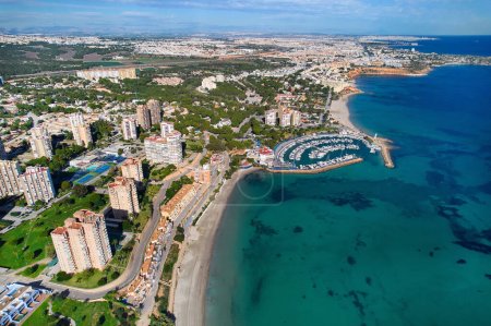 Drone point of view, aerial shot of Dehesa de Campoamor during sunny day with residential building and Mediterranean Sea view. Costa Blanca, Alicante. Spain. Travel and tourism concept