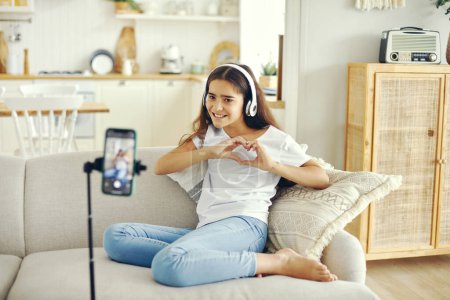 Photo for Preteen 12s girl blogger record video for vlog, showing heart sign, make call, lead stream with friends use modern tech. Streamer activity, igeneration, fun and home use internet, screen camera view. - Royalty Free Image