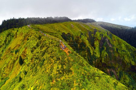 Photo for Aerial shot, drone point of view Boca do Inferno, lot of tourists walk along footpath, pathway lead to edge of hills with beautiful views to the volcanic lakes. Ponta Delgada island, Azores, Portugal - Royalty Free Image