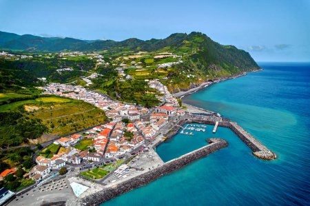 Luftaufnahme der Stadt Povoacao, Insel Sao Miguel im portugiesischen Archipel der Azoren. Yachthafen mit festgemachten Booten, Dächern der Stadt und Umgebung grüne Hügel Blick von oben. Ponta Delgada. Portugal
