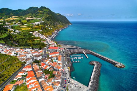 Luftaufnahme der Stadt Povoacao, Insel Sao Miguel im portugiesischen Archipel der Azoren. Yachthafen mit festgemachten Booten, Dächern der Stadt und Umgebung grüne Hügel Blick von oben. Ponta Delgada. Portugal