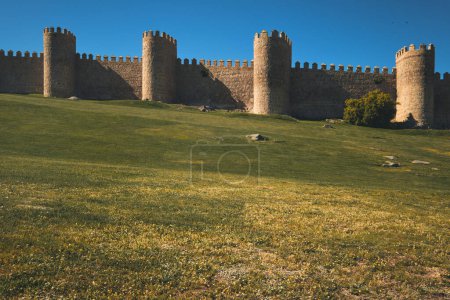 Photo for View to The Walls of Avila historic city, against blue sky during sunny day. Famous fortification, spanish landmark in Castile and Leon. UNESCO. Spain - Royalty Free Image