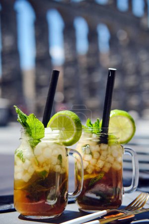 Téléchargez les photos : Fermer deux tasses avec des cocktails mojito sur fond d'aqueduc romain dans la ville de Ségovie. Espagne - en image libre de droit
