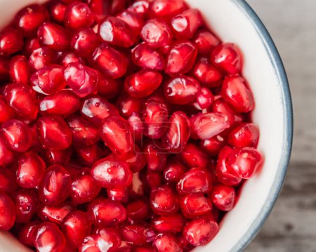 Photo for Close up of juicy organic pomegranate seeds in a bowl. - Royalty Free Image