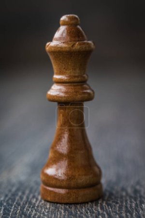 Exquisite black queen chess piece displayed on a wooden table, testament to strategic gameplay.