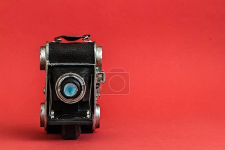 Photo for Decorative nostalgic camera figurine on red background, vintage charm, with copy space. - Royalty Free Image