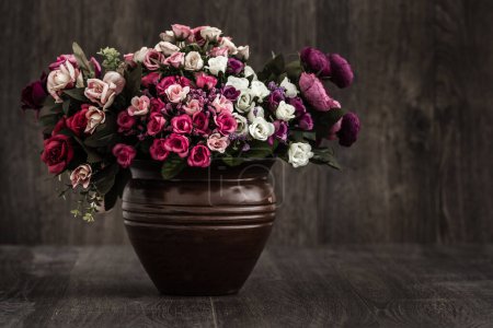 Photo for Colorful spring bouquet in a rustic flowerpot, vibrant pink and purple blossoms, beautiful home decor. - Royalty Free Image