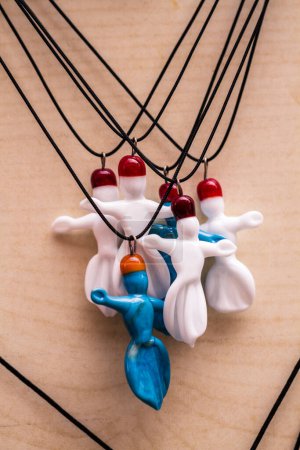 Handcrafted multicolored murano glass whirling dervish necklaces displayed on a light background.