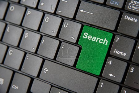 Close up of a green search key on a black keyboard, emphasizing modern digital exploration