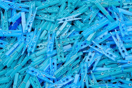 Close up of a pile of blue plastic clothespins on a counter in an open marketplace, texture, background.