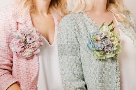 Photo for Two fair-haired women in tweed jackets and brooches in the shape of a flower - Royalty Free Image