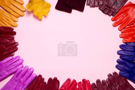 Photo for Many bright multi-colored gloves are laid out in a circle on a pink background - Royalty Free Image