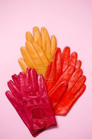 Photo for Bright multi-colored gloves on a pink background - Royalty Free Image