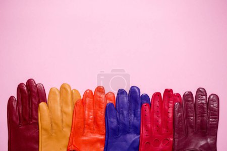 Photo for Many bright multi-colored gloves on a pink background - Royalty Free Image