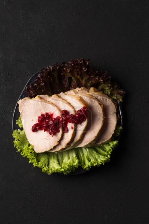 Foto de Delicious juicy sliced ham with lettuce on a dark background - Imagen libre de derechos