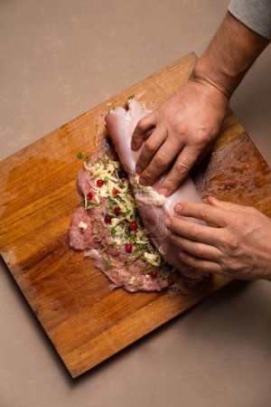 Photo for The process of stuffing turkey fillet for the Christmas table, the work of dad and child - Royalty Free Image