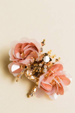 Decorative handmade brooch in the shape of a beetle on a beige background