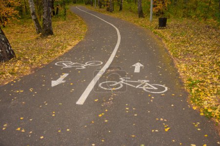 Téléchargez les photos : Piste cyclable avec panneaux routiers dans la forêt d'automne - en image libre de droit