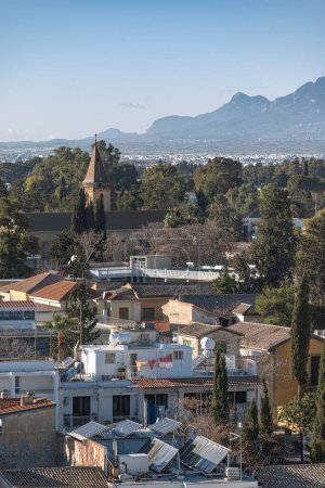 Elevated view of Nicosia showcasing historical church against a backdrop of majestic mountains. Cyprus
