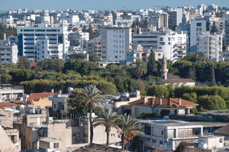 Erhöhter Blick auf Nikosias modernes Stadtbild mit Gebäuden und Palmen unter klarem Himmel