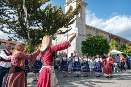 Photo for Lania, Limassol District, Cyprus - May 13, 2023: Villagers dressed in folk costumes perform a traditional dance near an old church, celebrating local culture - Royalty Free Image