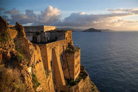 Hermoso paisaje marino de la isla de Procida. Vista del Castillo de los Avalos y del Volcán Vesubio en la parte trasera. Campania. Italia.