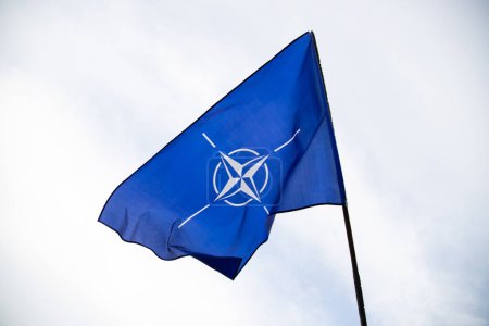 Foto de NATO (North Atlantic Treaty Organization) flag waving. NATO is an international military alliance that constitutes a system of collective security - Imagen libre de derechos