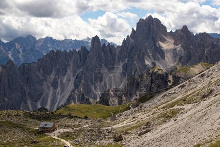 Téléchargez les photos : Rifugio Lavaredo avec de beaux sommets montagneux du groupe Cadini à Sexten Dolomites. Cabane de montagne avec des touristes sur le sentier de boucle autour de Tre Cime di Lavaredo, Dolomites, Tyrol du Sud, Italie. - en image libre de droit