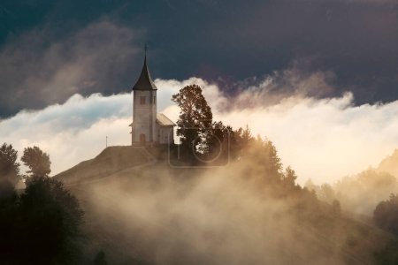 Jamnik, Slowenien. Die Kirche Jamnik ist eine bezaubernde Kapelle aus dem 15. Jahrhundert in den Kamnik-Savinja-Alpen in der Nähe von Kranj, mit atemberaubender Aussicht auf die umliegende Berglandschaft.
