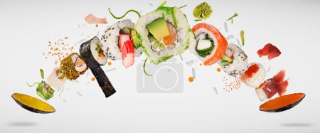 Foto de Trozos de delicioso sushi japonés congelado en el aire. Aislado sobre fondo blanco - Imagen libre de derechos