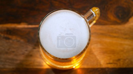 Photo for Freshly brewed beer in a pint on old wooden table, close-up - Royalty Free Image