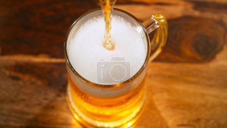 Téléchargez les photos : Pouring beer into glass on old wooden table, close-up - en image libre de droit