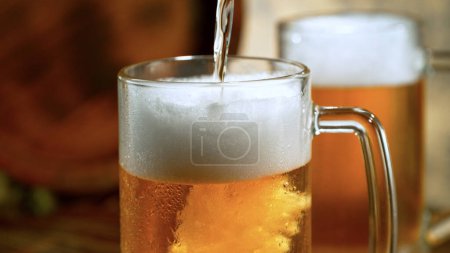 Téléchargez les photos : Pouring beer into glass on old wooden table, close-up - en image libre de droit
