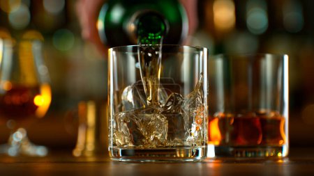 Photo for Close-up of pouring whiskey or rum in a pub - Royalty Free Image