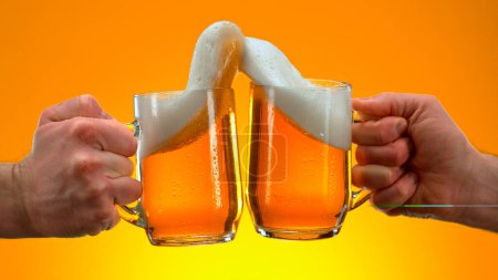Foto de Freeze Motion Shot of Clinking Two Glasses of Beer, Close-up - Imagen libre de derechos