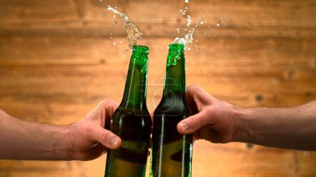Téléchargez les photos : Freeze Motion Shot of Clinking Two Bottles of Beer, Close-up - en image libre de droit